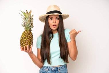 hispanic pretty woma feeling puzzled and confused and doubting. pineapple and summer concept