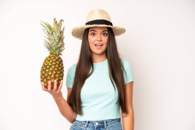hispanic pretty woma feeling happy and pointing to self with an excited. pineapple and summer concept