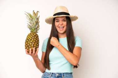 hispanic pretty woma feeling happy and astonished at something unbelievable. pineapple and summer concept