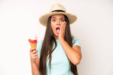 hispanic pretty woma feeling shocked,laughing and celebrating success. ice cream and summer concept