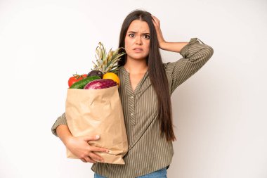 hispanic pretty woma shouting aggressively, looking very angry. market vegetables bag concept