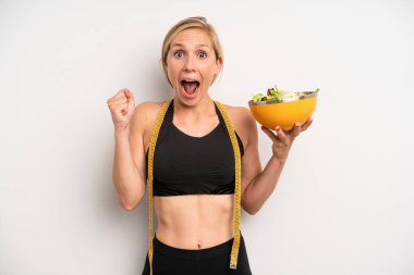 Kafkasyalı bir kadın şoke olmuş, gülüyor ve başarıyı kutluyor. salata ve diyet konsepti