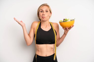 Kafası karışmış, kafası karışmış ve şüpheci bir beyaz kadın. salata ve diyet konsepti