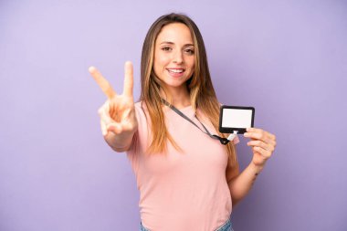 Güzel beyaz kadın gülümseyen ve mutlu görünen, zafer ya da barış işareti yapan. VIP geçiş kartı konsepti