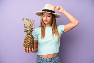 Güzel beyaz kadın mutlu bir şekilde gülümsüyor ve hayal kuruyor ya da şüphe ediyor. yaz ve ananas konsepti