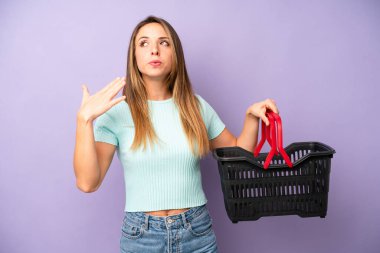 Oldukça beyaz bir kadın stresli, endişeli, yorgun ve hayal kırıklığına uğramış hissediyor. boş alışveriş sepeti kavramı