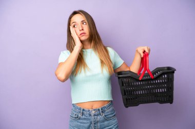 Oldukça beyaz bir kadın bıkkın, hayal kırıklığına uğramış ve yorucu bir geceden sonra uykulu hissediyor. boş alışveriş sepeti kavramı