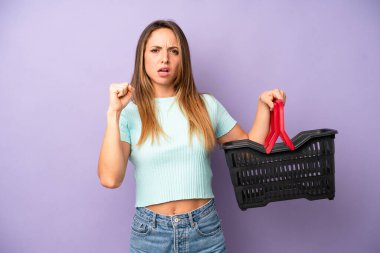 Kafkas bir kadın sinirli bir ifadeyle agresif bir şekilde bağırıyor. boş alışveriş sepeti kavramı