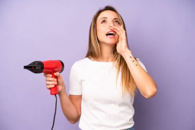 Kafkasyalı bir kadın kendini mutlu hissediyordu, elleri ağızının yanında bağırıyordu. saç kurutma makinesi konsepti