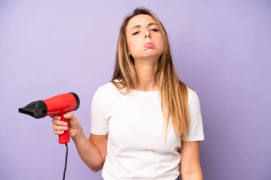 Kafkasyalı bir kadın üzgün ve mızmızlanıyor. Mutsuz bir bakışı var ve ağlıyor. saç kurutma makinesi konsepti