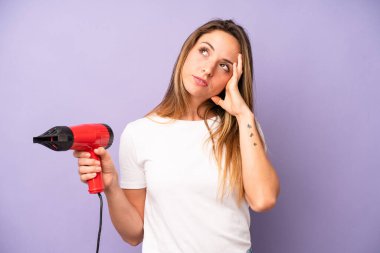 Oldukça beyaz bir kadın bıkkın, hayal kırıklığına uğramış ve yorucu bir geceden sonra uykulu hissediyor. saç kurutma makinesi konsepti