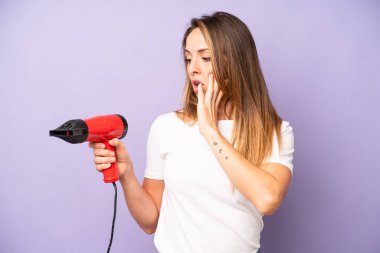 Kafkasyalı bir kadın mutlu, heyecanlı ve şaşırmış hissediyor. saç kurutma makinesi konsepti