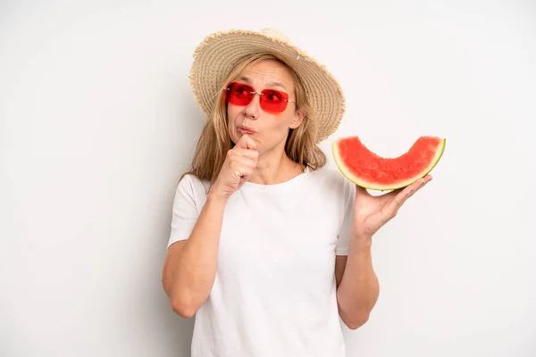 pretty caucasian woman thinking, feeling doubtful and confused. summer and watermelon concept