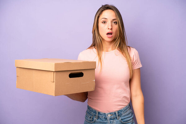 pretty caucasian woman looking very shocked or surprised. cardboard box concept