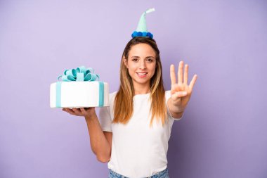 Güzel beyaz kadın gülümsüyor ve arkadaş canlısı görünüyor, dört numarayı gösteriyor. Doğum günü pastası konsepti