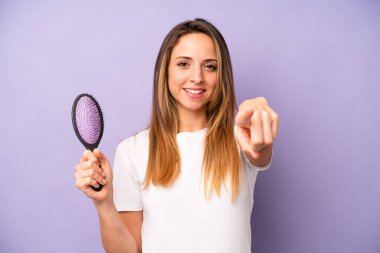 Kamerayı gösteren beyaz bir kadın seni seçiyor. saç tarağı konsepti