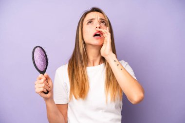 Kafkasyalı bir kadın kendini mutlu hissediyordu, elleri ağızının yanında bağırıyordu. saç tarağı konsepti