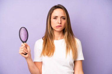 Kafası karışmış ve kafası karışmış beyaz bir kadın. saç tarağı konsepti