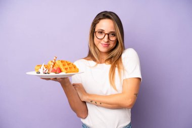 Beyaz bir kadın omuz silkiyor, kafası karışık ve kararsız. Waffle ve kahvaltı konsepti
