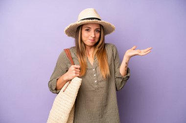 Kafası karışmış, kafası karışmış ve şüpheci bir beyaz kadın. yaz ve şapka konsepti