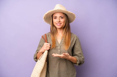 Güzel, beyaz bir kadın neşeyle gülümsüyor, mutlu hissediyor ve bir konsept gösteriyor. yaz ve şapka konsepti