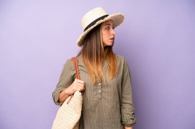 Profil görünümlü beyaz bir kadın hayal kuruyor, hayal kuruyor ya da hayal kuruyor. yaz ve şapka konsepti