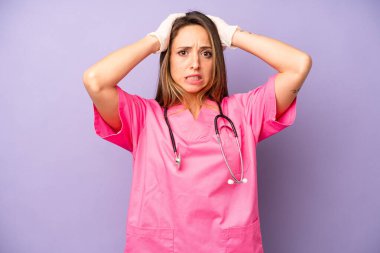 Kafkasyalı bir kadın stresli, endişeli ya da korkmuş, elleri başının üstünde. tıp doktoru konsepti