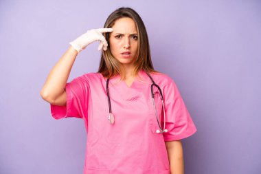 Kafası karışmış ve kafası karışmış beyaz bir kadın. Deli olduğunu gösteriyor. tıp doktoru konsepti