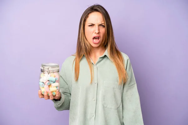 Pretty Caucasian Woman Shouting Aggressively Looking Very Angry Candies Bottle — Stockfoto