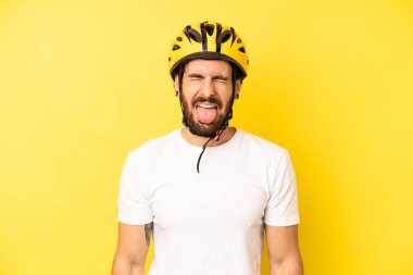 Çılgın sakallı, neşeli ve asi tavırlı, şaka yapan ve dilini dışarı çıkaran bir adam. bisiklet kaskı konsepti