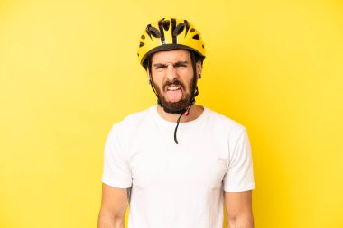 Çılgın sakallı adam iğreniyor, sinirleniyor ve dili dışarı çıkıyor. bisiklet kaskı konsepti