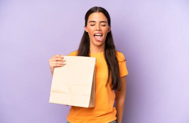 Neşeli ve asi tavırları olan, şaka yapan ve dilini dışarı çıkaran güzel İspanyol bir kadın. kahve konseptini kaldır.