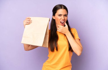 Ağzı ve gözleri sonuna kadar açık ve eli çenesinde olan güzel İspanyol bir kadın. kahve konseptini kaldır.