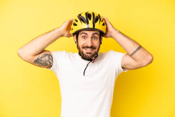 crazy bearded man feeling stressed, anxious or scared, with hands on head. bike helmet concept