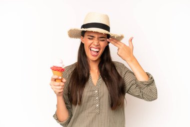 Oldukça İspanyol bir kadın mutsuz ve stresli görünüyor, intihar jesti silah işareti yapıyor. dondurma ve yaz konsepti