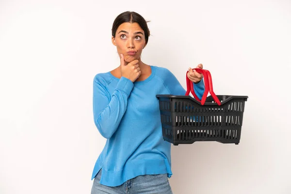 Pretty Hispanic Woman Thinking Feeling Doubtful Confused Empty Shopping Basket — Stock Photo, Image