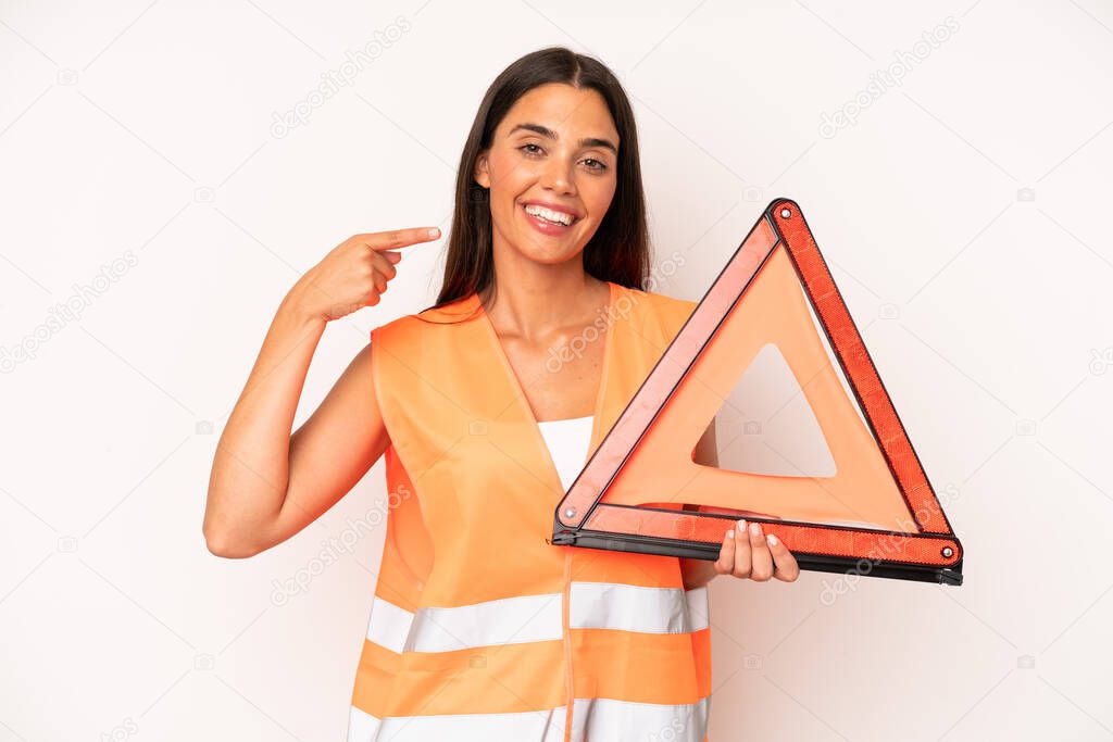 pretty hispanic woman smiling confidently pointing to own broad smile. car emergency concept