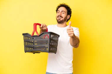 Çılgın sakallı adam gururlu, olumlu gülümsüyor. boş pazar sepeti kavramı