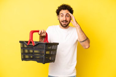 Çılgın sakallı adam mutlu, şaşkın ve şaşırmış görünüyor. boş pazar sepeti kavramı