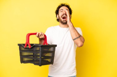 Çılgın sakallı adam mutlu hissediyor, elleri ağzının kenarında bağırıyor. boş pazar sepeti kavramı