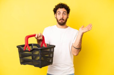 Çılgın sakallı adam şaşırmış ve şok olmuş görünüyor. Çenesi düşmüş ve elinde bir nesne var. boş pazar sepeti kavramı
