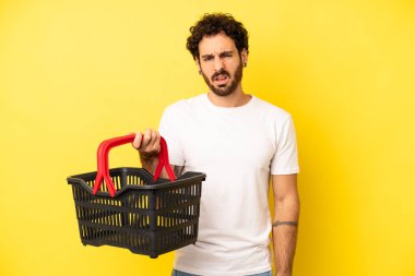 Çılgın sakallı adam şaşkın ve şaşkın hissediyor. boş pazar sepeti kavramı