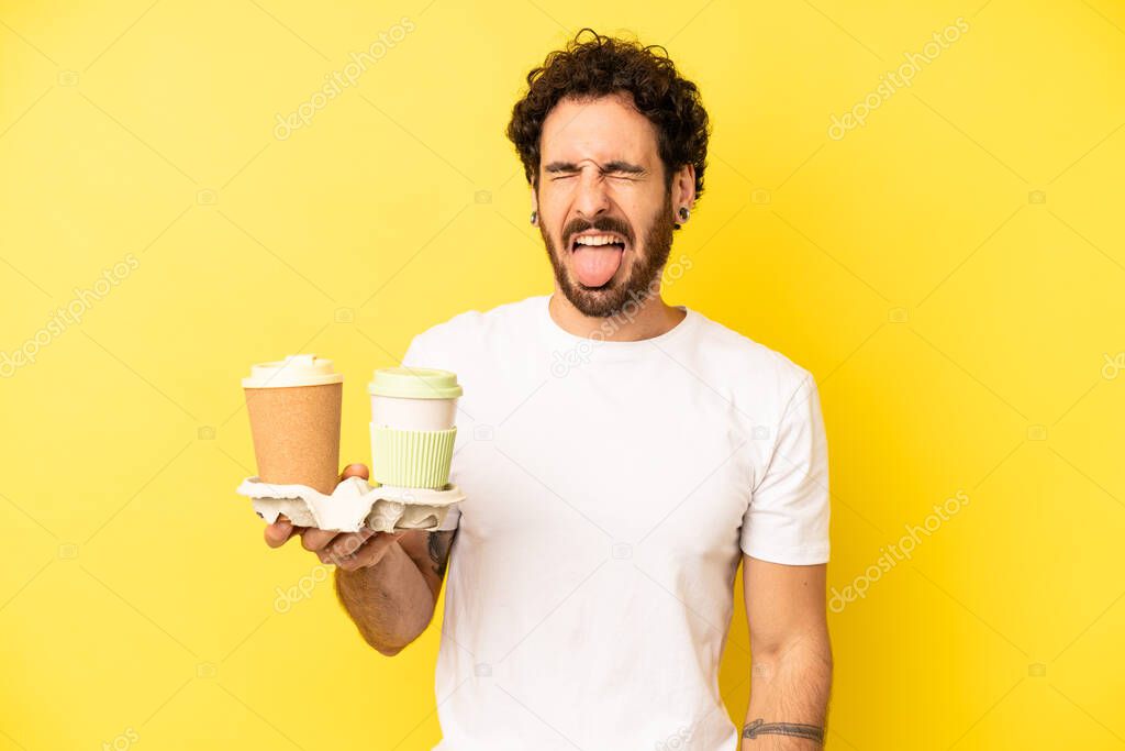 crazy bearded man with cheerful and rebellious attitude, joking and sticking tongue out. take away coffee concept