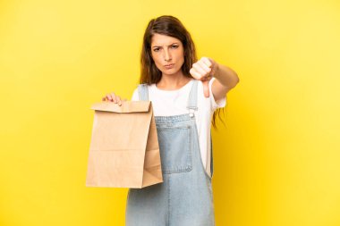 pretty caucasian woman feeling cross,showing thumbs down. take away concept