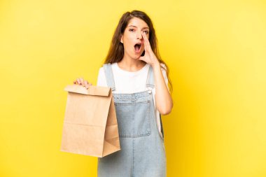 pretty caucasian woman feeling happy,giving a big shout out with hands next to mouth. take away concept
