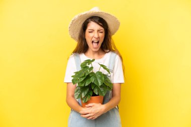 pretty caucasian woman shouting aggressively, looking very angry. gardering concept