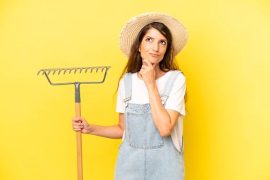 pretty caucasian woman thinking, feeling doubtful and confused. farmer concept
