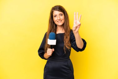 pretty caucasian woman smiling and looking friendly, showing number three. tv presenter concept