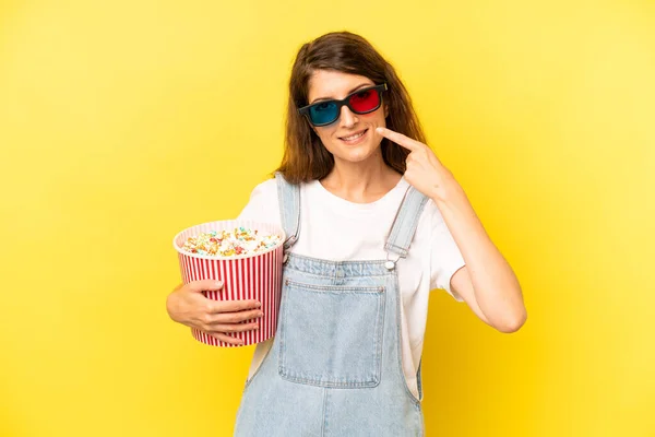 pretty caucasian woman smiling confidently pointing to own broad smile. film or movie concept