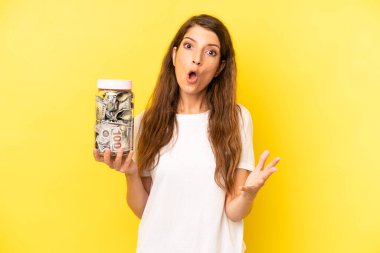 pretty caucasian woman amazed, shocked and astonished with an unbelievable surprise. dollar banknotes savings